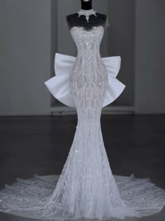 the back of a white wedding dress on display in front of a mannequin