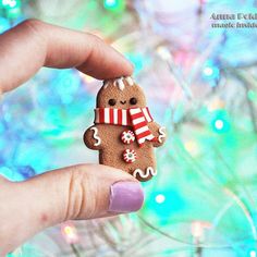 a hand holding a small gingerbread with candy canes