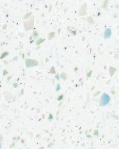 a white counter top with lots of different colored rocks on it's surface,