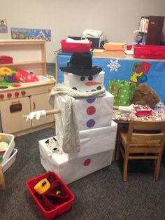 there is a snowman made out of boxes and other toys in the room with children's play equipment