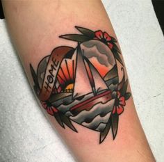 a tattoo with a sailboat on it and the sun setting in the sky behind it