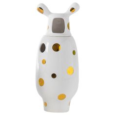 a white vase with gold polka dots on the top and bottom, sitting in front of a white background