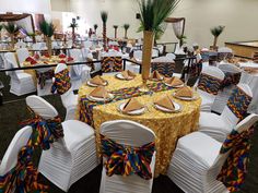 a banquet room set up with white chairs and yellow table cloths, decorated with palm trees