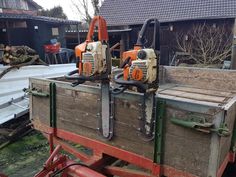 two chainsaws sitting on top of a wooden box