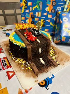 a birthday cake that is shaped like a construction truck on top of dirt and sprinkles