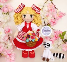 a crocheted doll holding a basket of flowers next to a raccoon