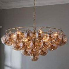 a chandelier hanging from the ceiling in a room with gray walls and windows