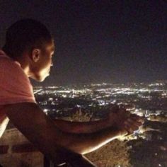 a man looking out over the city at night