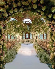 an outdoor ceremony area with chairs and flowers on the aisle, surrounded by greenery