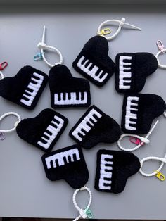 several black and white pieces of cloth with strings attached to them, all have musical notes on them