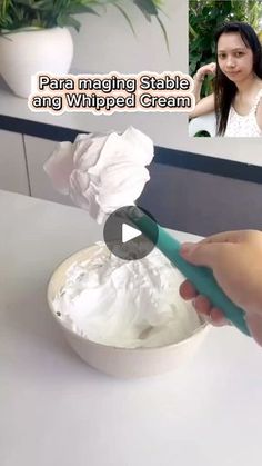 a woman is making whipped cream in a white bowl with a green handled spatula