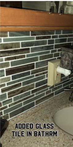 a bathroom sink under a mirror with the words added glass tile in bottom and bottom