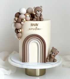 a baby shower cake with teddy bears and balloons on the top, sitting on a plate