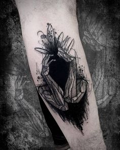 a man's arm with black ink on it and an abstract design in the middle