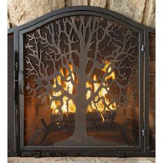 a fire place with a tree cutout on the top and flames coming out from it