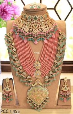 an elaborate necklace and earring set on display in front of a vase with flowers