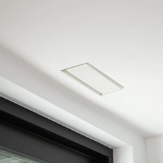 the ceiling is white and has a square light fixture above it, along with a black door