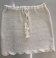 a crocheted white skirt hanging on a hook