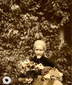 an old photo of a woman holding flowers