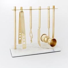 a set of kitchen utensils hanging from a rack on a marble countertop