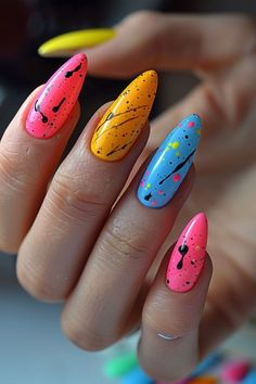 a woman's hand with multicolored nail polishes on her nails and two yellow, blue, red, and orange tips