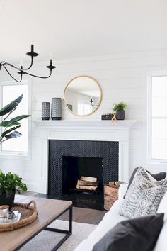 a living room filled with furniture and a fire place in front of a white fireplace