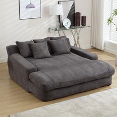 a large gray couch sitting on top of a hard wood floor