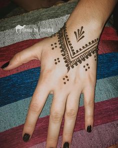 a woman's hand with a henna tattoo on it