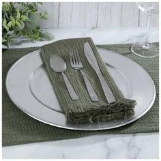 a place setting with silverware and green napkins