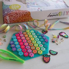 there is a craft kit with beads and scissors on the table next to some other items