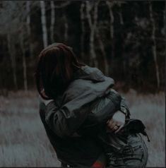 a woman walking through a field with her back to the camera, carrying a backpack