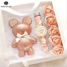 a pink teddy bear and some flowers in a box