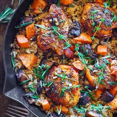 a skillet filled with rice, carrots and chicken