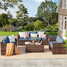 an outdoor patio with wicker furniture and blue cushions