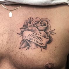 a man with a tattoo on his chest has a rose and a ribbon that says mom