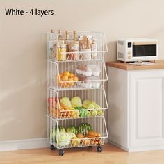 a white four layer rack with fruits and vegetables next to a microwave on a counter