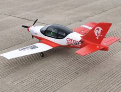 a small red and white airplane on the ground