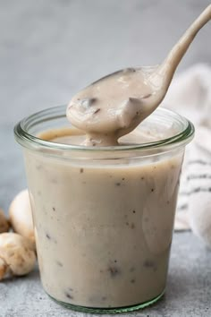 a spoon full of peanut butter sitting in a jar