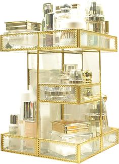 an assortment of cosmetics and makeup products in a gold display case on a white background