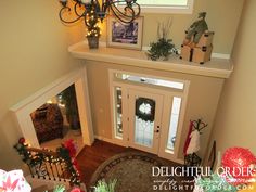 an overhead view of a decorated entryway with christmas decorations and wreaths on the stairs