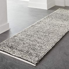 a white and black rug on the floor in an empty room with no people around it