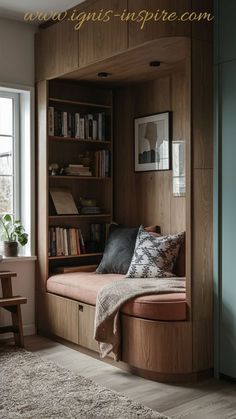 a window seat in the corner of a room with bookshelves and a rug