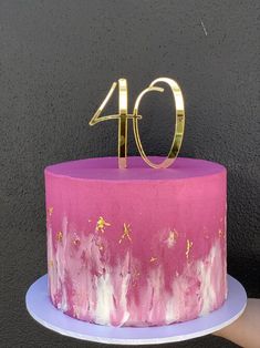 a pink and gold cake with the number forty on it