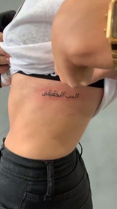 a woman's stomach with arabic writing on it