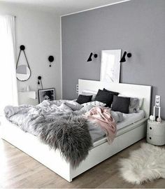 a white bed sitting in a bedroom on top of a hard wood floor