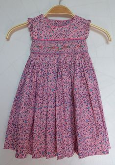 Pretty pink flowery girl dress. It is finely embroidered by hand on the front. A smock dress in a beautiful 100% cotton fabric. Dress to wear on all occasions. Exists from 3 months to 10 years Pink Cotton Sundress With Smocked Back, Cotton Smocked Dress With Floral Print For Beach, Cute Pink Cotton Smocked Dress, Cotton Sundress With Smocked Bodice For Garden Party, Sleeveless Cotton Smocked Dress With Floral Print, Pink Cotton Smocked Sundress, Sleeveless Cotton Smocked Dress For Garden Party, Pink Cotton Sundress With Smocked Detail, Pink Cotton Embroidered Dress For Spring