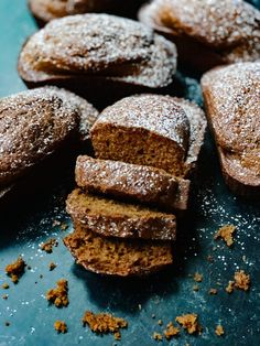 there are several pieces of bread on the table with powdered sugar scattered around it