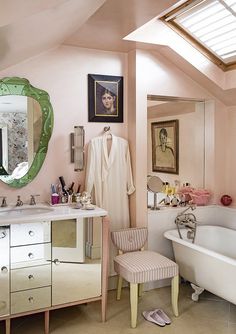 a bath room with a sink a mirror and a bath tub under a large mirror