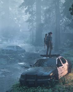 a man standing on top of two cars in the woods