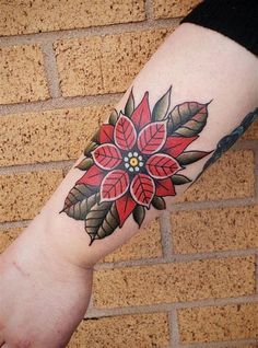 a woman's arm with a flower tattoo on it